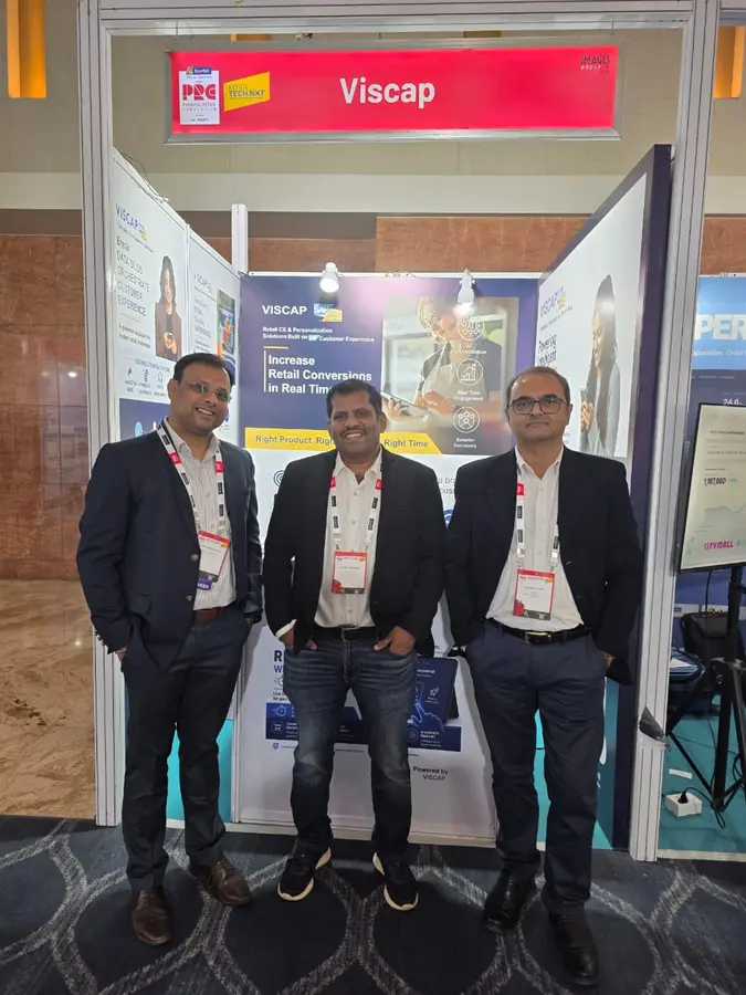 Drei Mitglieder des VISCAP-Teams am Stand, unter dem Panel Increase Retail Conversions in Real Time.