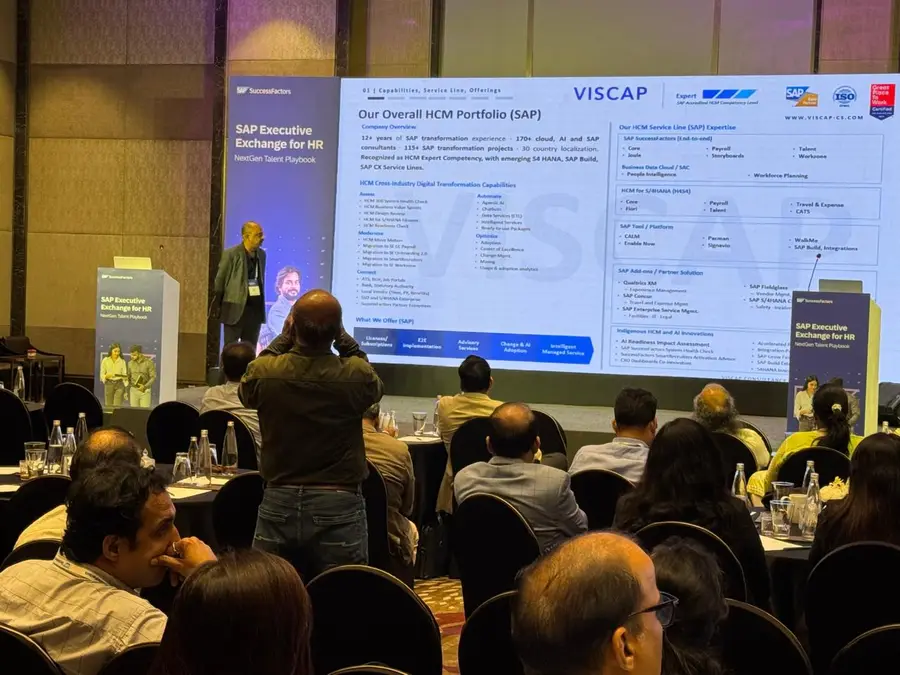 A VISCAP presenter on stage with VISCAP&rsquo;s SAP HCM portfolio slide on the screen behind him.