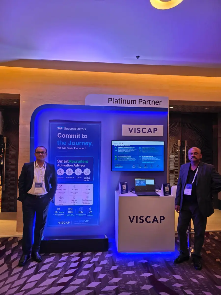 Two members of the VISCAP team standing either side of the VISCAP stand, under the Platinum Partner sign.