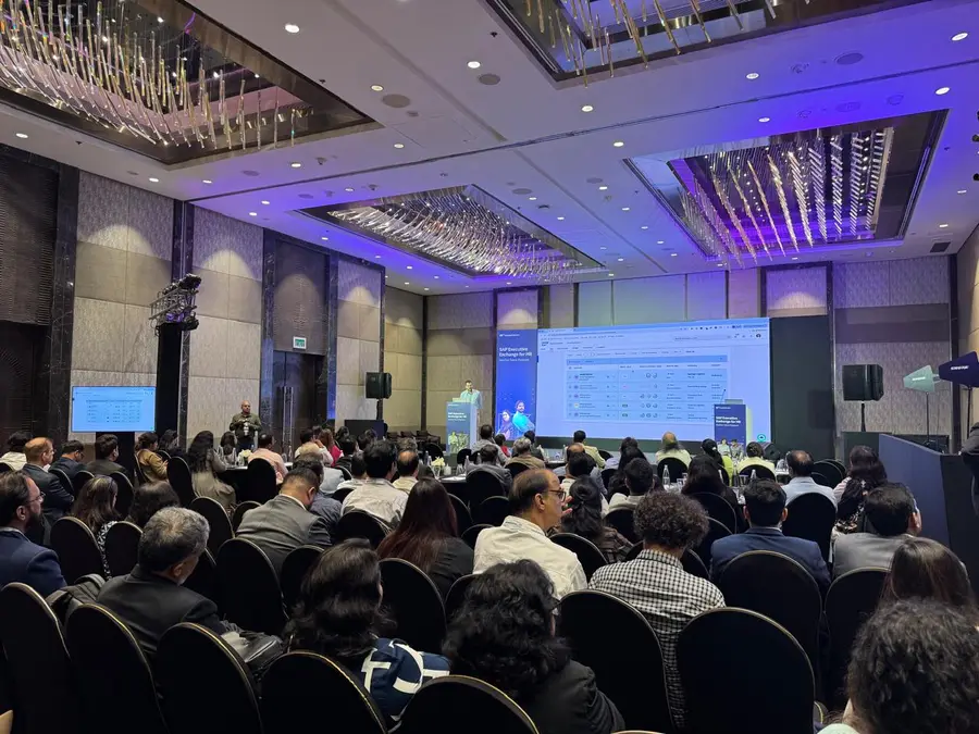 The room from the back during a session, with the SAP Executive Exchange for HR title card and a SuccessFactors recruiting screen on stage.