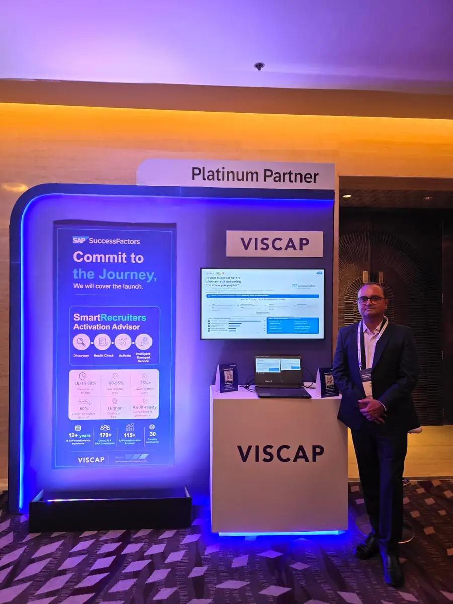 A member of the VISCAP team at the stand, beside a screen asking whether a SuccessFactors platform still delivers the value you pay for.