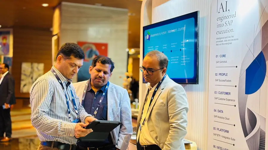 Colleagues looking through something on a laptop together at the VISCAP stand.