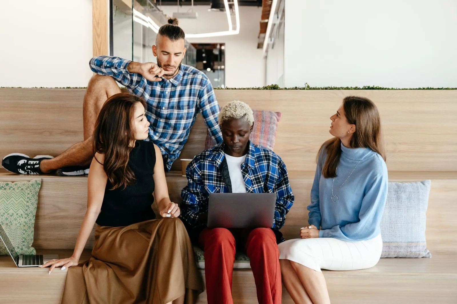 Colleagues collaborating around a laptop